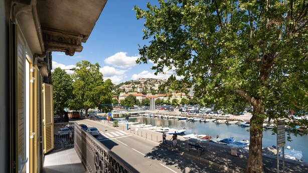 A balcony with a view of a marina, boats, and a distant town. - Premium apartments with balcony (Rijeka)