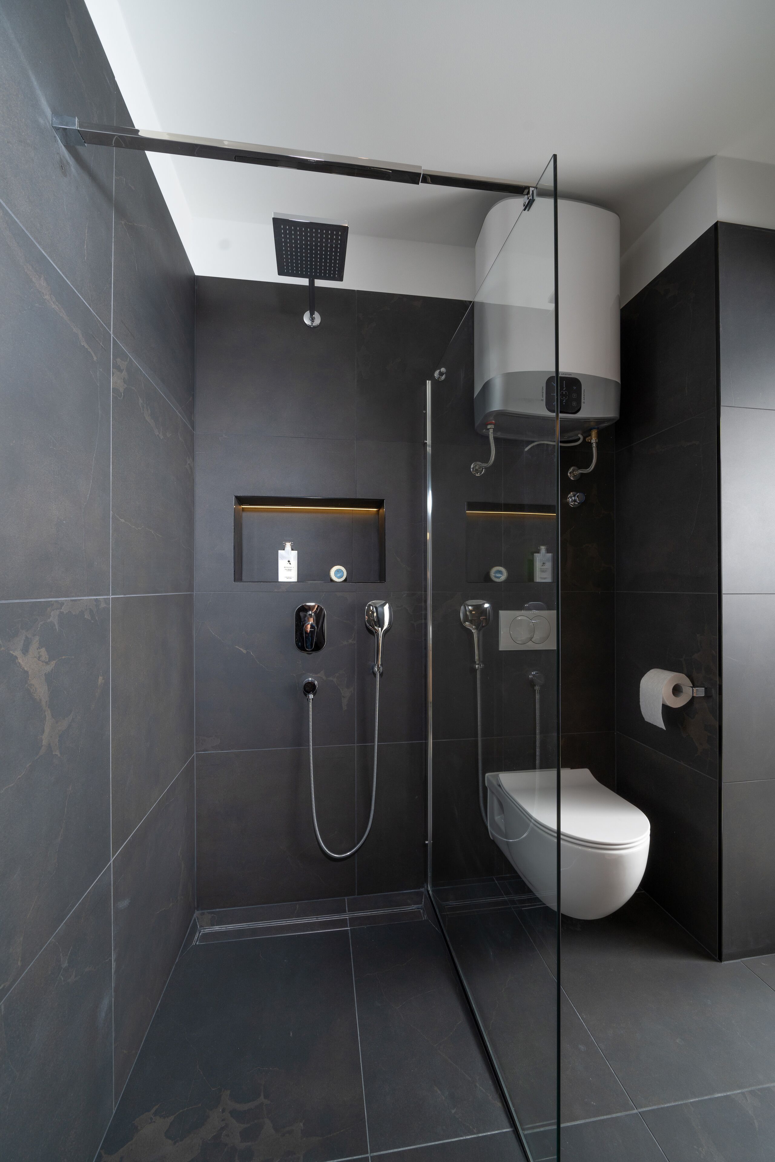 Un baño moderno con ducha acristalada, inodoro y lavamanos.