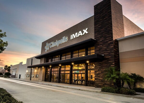 A Cinepolis IMAX cinema with a modern facade, large windows, and a well-lit entrance.