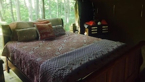 Un dormitorio acogedor con cama, almohadas y mesita de noche.