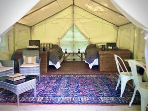 Cozy tent interior with two separate sleeping areas, each with a bed and pillow.