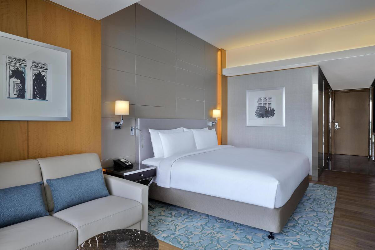 Ein Hotelzimmer mit einem Bett, einem Schlafsofa, einem Nachttisch und einer Lampe.