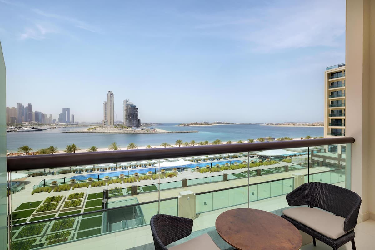 Ein Balkon mit Blick auf einen Yachthafen, einen Poolbereich und hohe Gebäude.