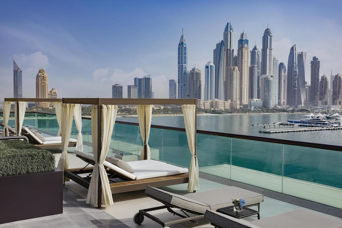 Eine Dachterrasse mit Blick auf die Stadtlandschaft, darunter ein Yachthafen mit Booten.