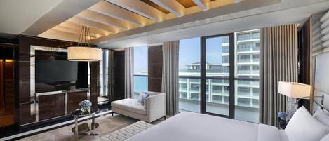 Une chambre d’hôtel moderne dotée d’un grand lit, d’une télévision, d’un canapé et offrant une vue sur la ville.