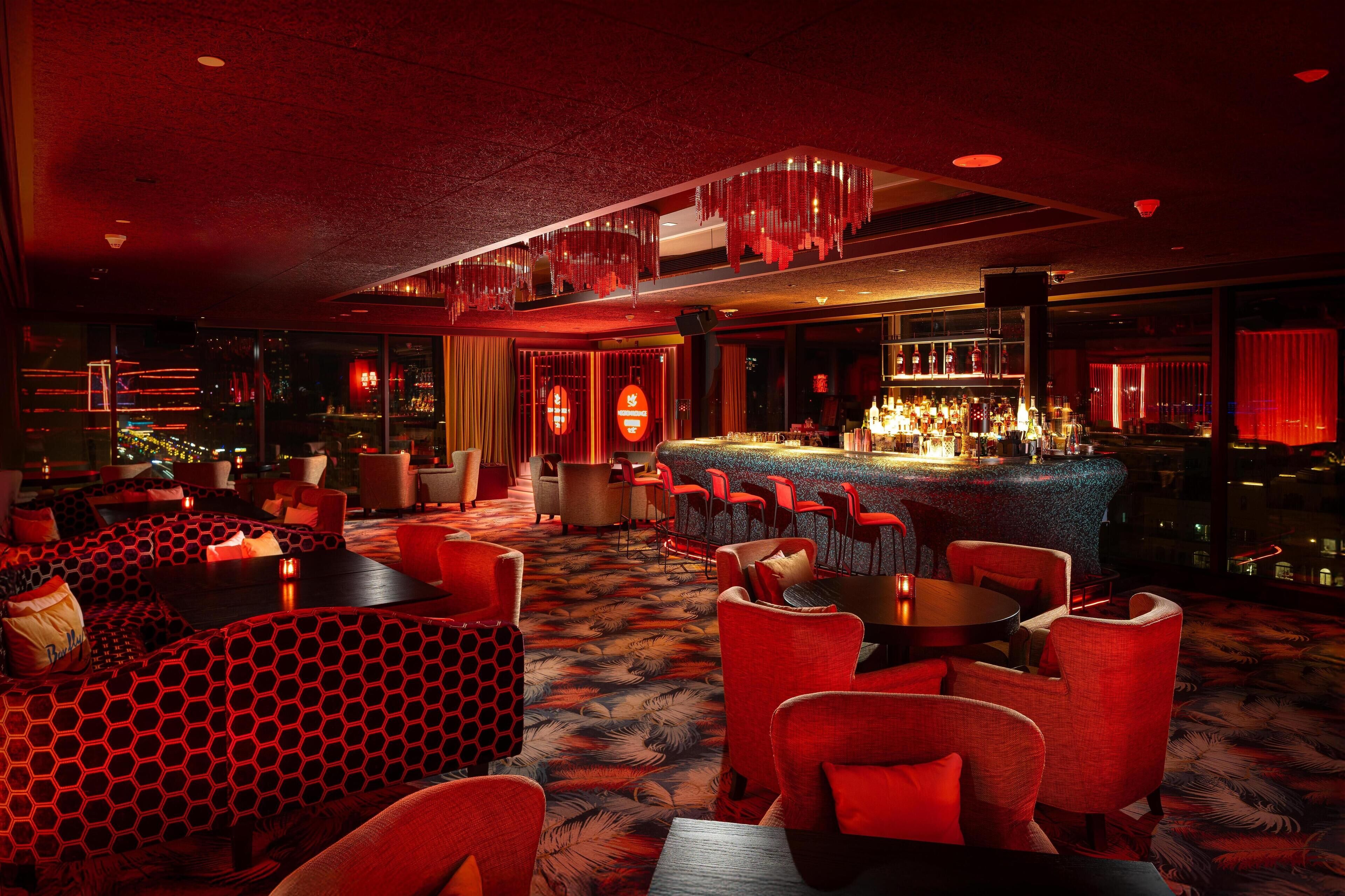 A bar area with red seating and a bar counter.