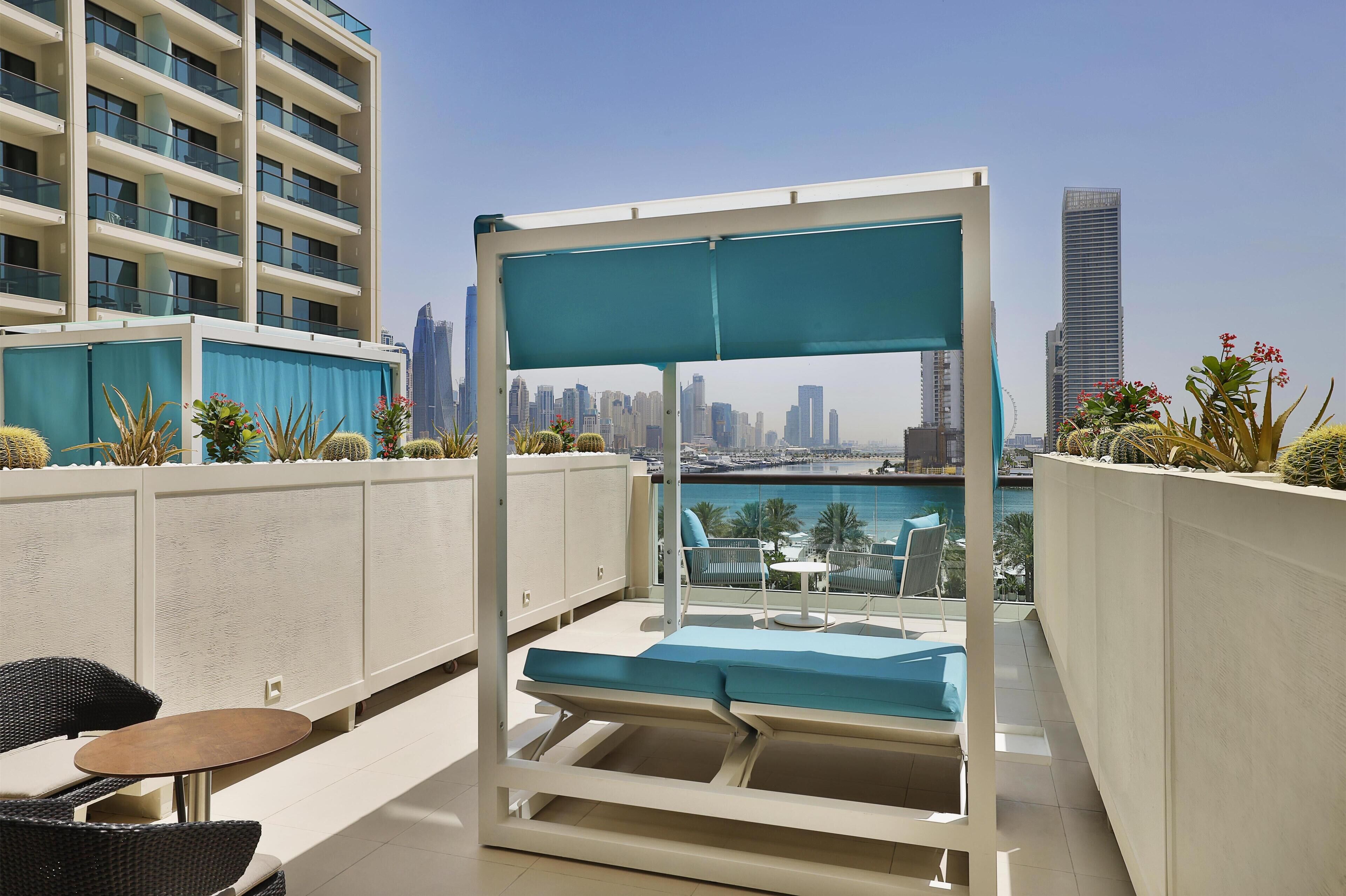 Terraza en la azotea con zona de estar, vistas del horizonte urbano y una piscina.