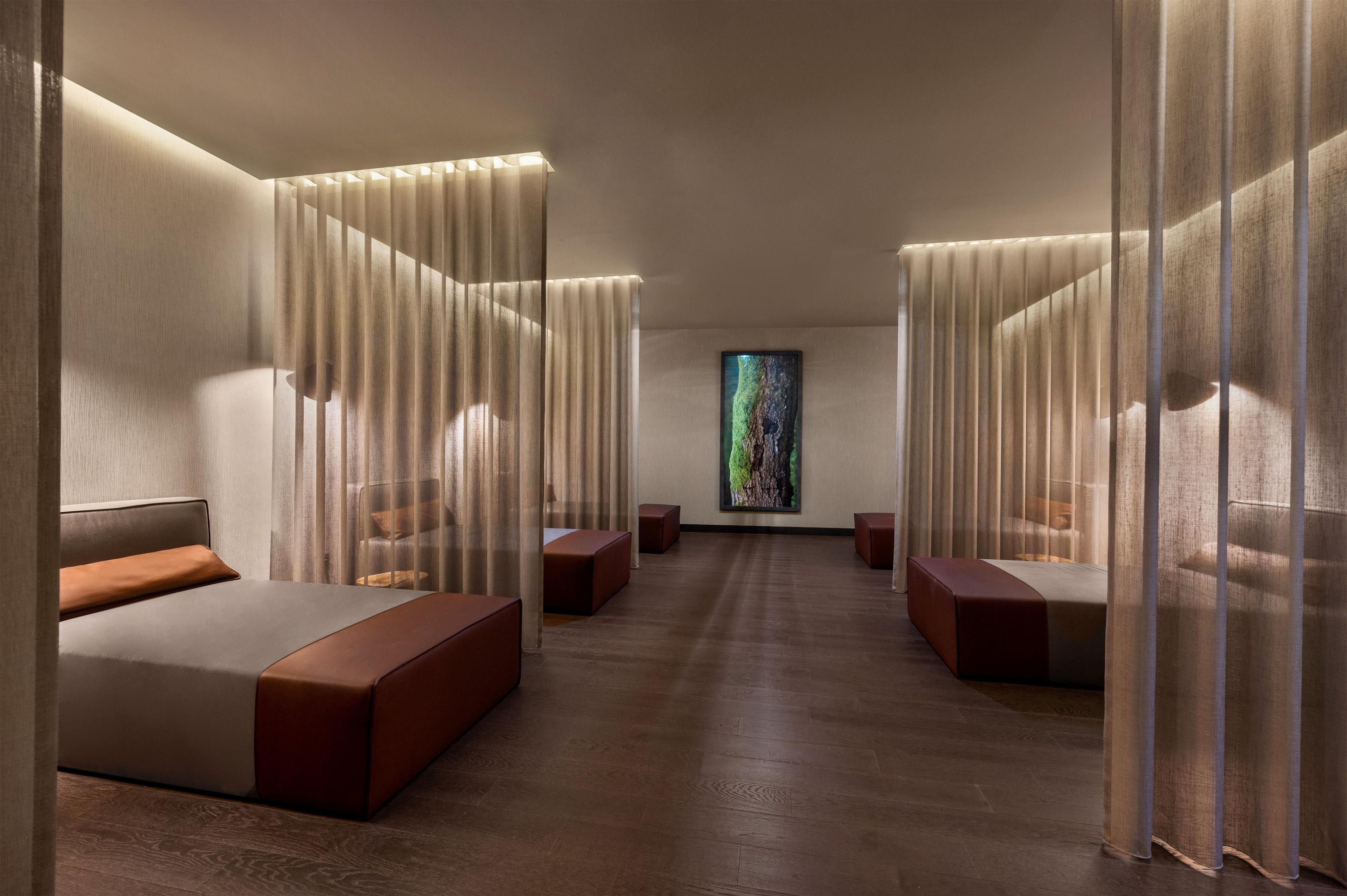 Un spa moderno con un área central de relajación, asientos acolchados y un amplio ventanal con vistas.