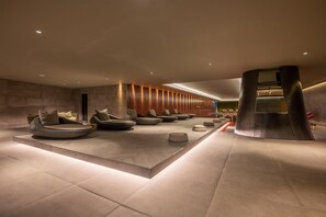 A modern lobby with a seating area featuring round chairs and a central column. - Hilton Porto Gaia (Vila Nova de Gaia)