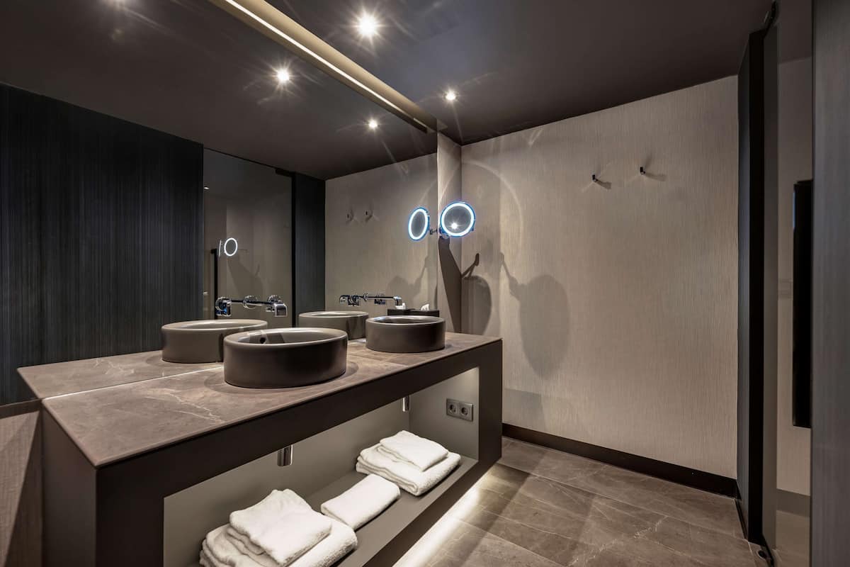 A modern bathroom with a dark wood vanity, two sinks, and a mirror.