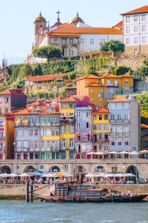 A waterfront area with colorful buildings, a church, and boats docked at the pier. - Hilton Porto Gaia (Vila Nova de Gaia)