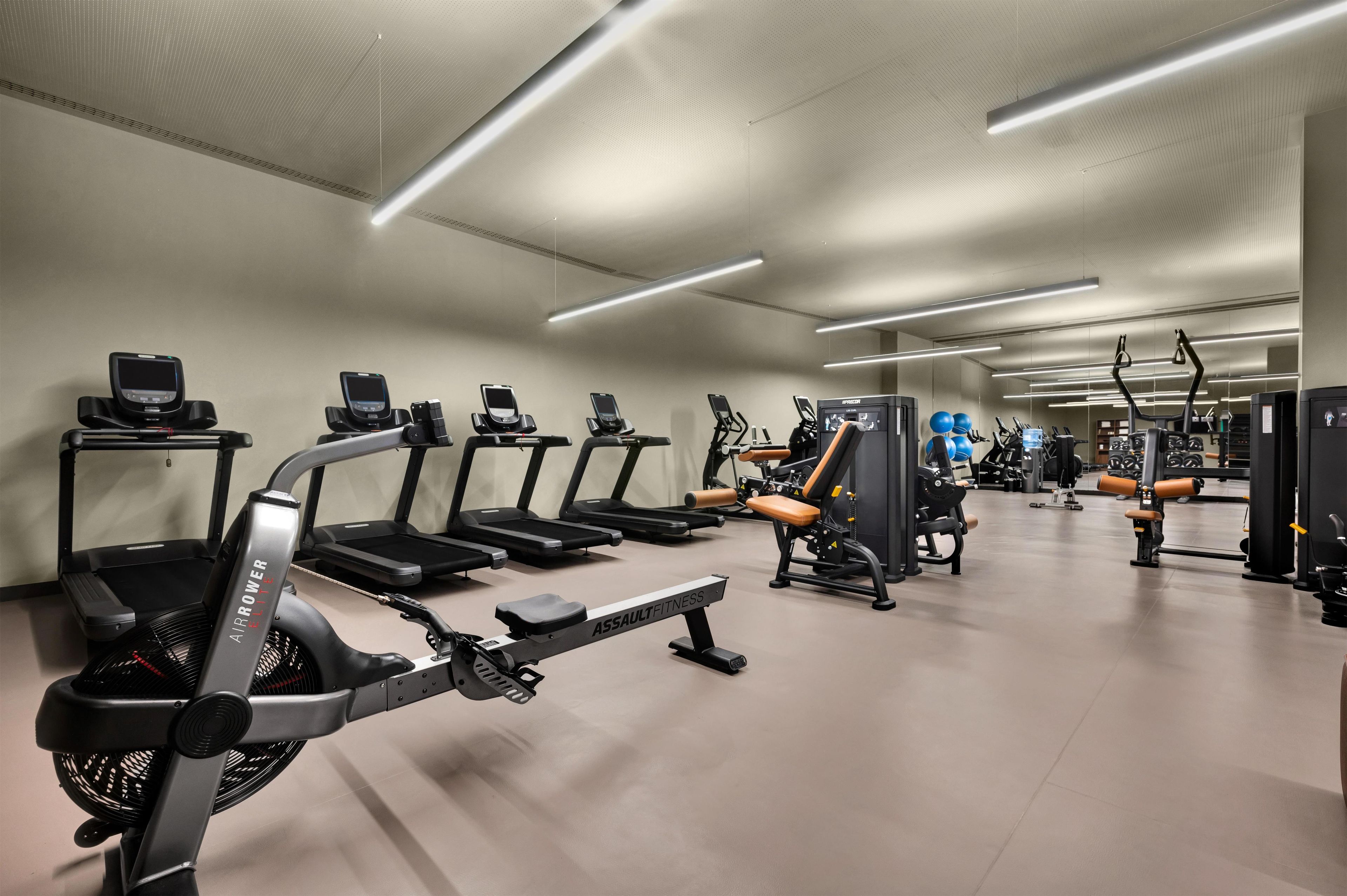 Academia equipada com esteiras, elípticos e equipamentos de musculação.