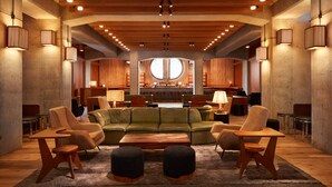 A spacious lobby with a green sofa, wooden chairs, and a central coffee table. - Ace Hotel Brooklyn (Brooklyn)