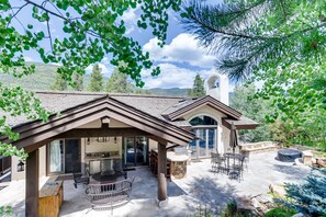 A house with a covered patio, outdoor seating, and a stone fireplace. - 2-2122 Vermont Road (Vail)