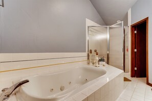 A bathroom with a large bathtub, a shower, and a mirror. - 2-2122 Vermont Road (Vail)