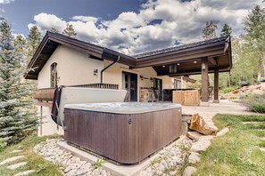 A modern house with a hot tub, outdoor seating, and a stone fireplace. - 2-2122 Vermont Road (Vail)
