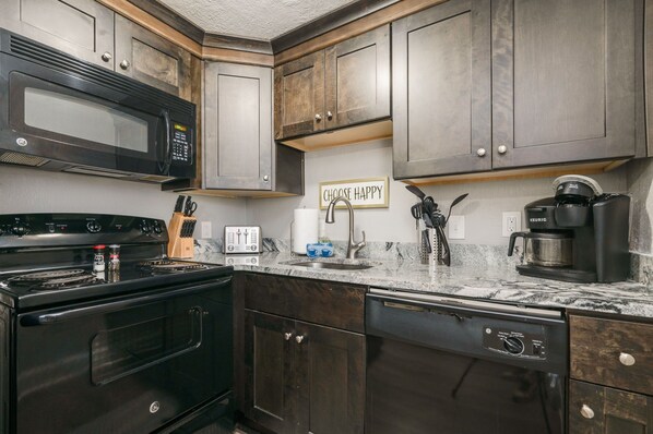 Enjoy cooking in this well-equipped kitchen with a stove, microwave, and coffee maker.