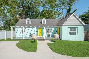 Welcome to a charming home with a covered patio area, perfect for relaxation, featuring a bathtub and two comfortable chairs.