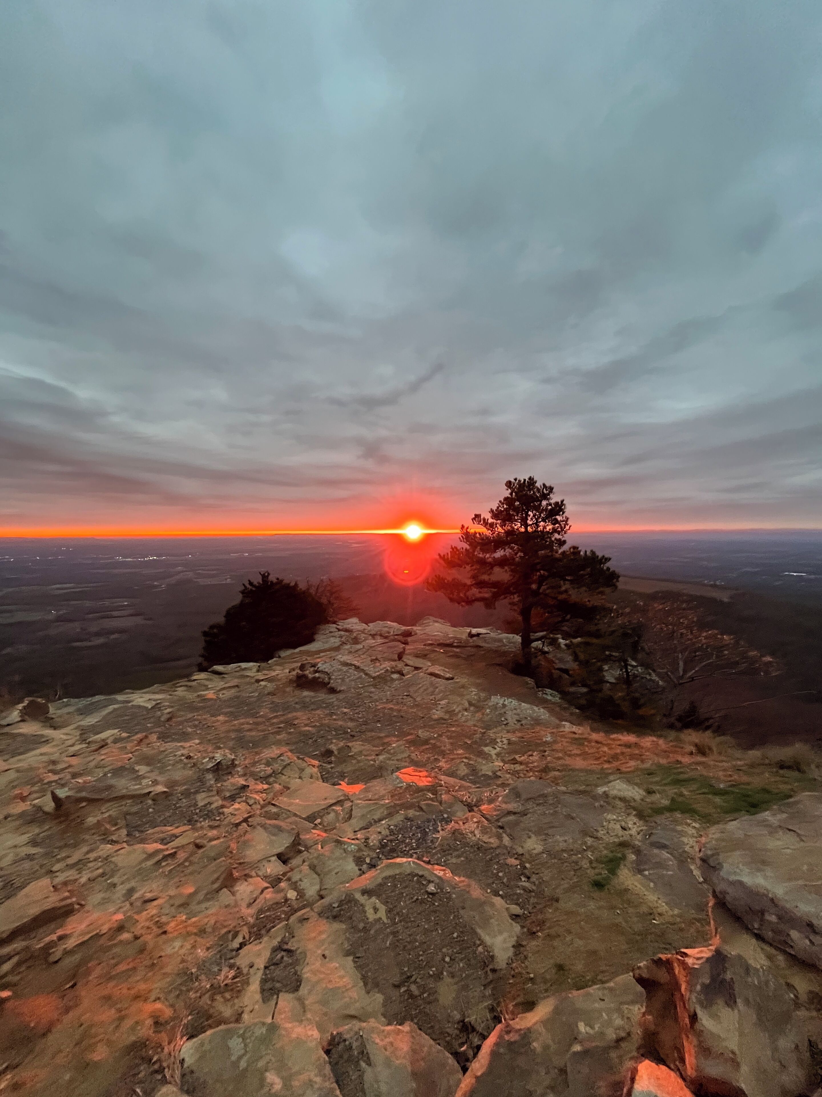 A rocky landscape with a sunset in the background.