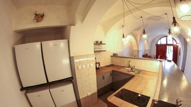 A kitchen with a central island, two wall-mounted refrigerators, and a wooden countertop. - Beautiful 4 Bedroom apartment (Chvalsiny)