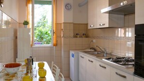 Une cuisine équipée d’une table à manger, de chaises, d’un évier, d’une cuisinière et de placards.