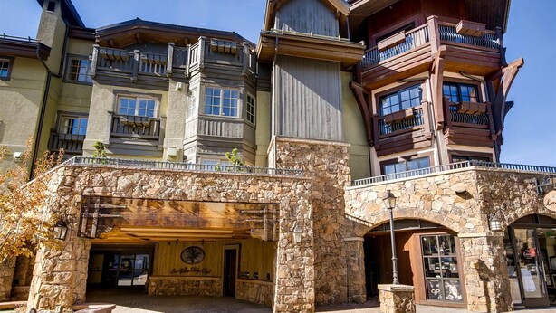 A multi-story building with a stone facade, multiple balconies, and a wooden entrance. - 1a-owb 36 (Vail)