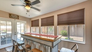 Una cocina con barra, ventilador de techo y un letrero que dice "Welcome to Patio".
