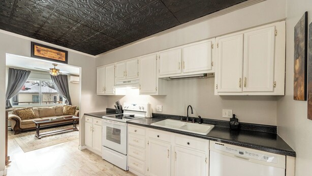 A kitchen with white cabinets, a black countertop, and a stainless steel oven. - Walking distance historic downtown Sheridan (Sheridan)