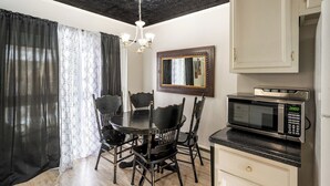 A dining area with a round table and four chairs, a wall-mounted mirror, a microwave, and a cabinet. - Walking distance historic downtown Sheridan (Sheridan)