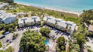 Un resort con piscina, acceso a la playa y varias edificaciones.