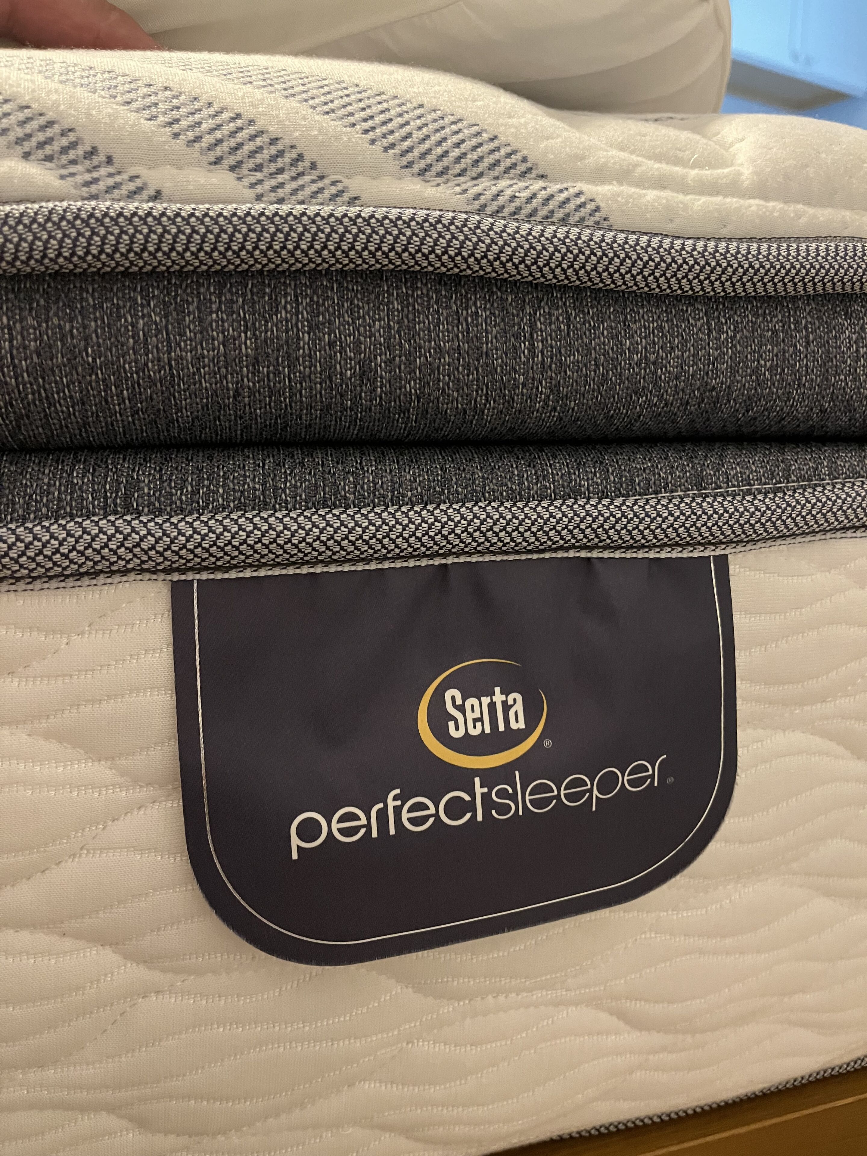 Un colchón plegado con una etiqueta que indica que es un 'Serta Perfectsleeper'.