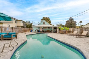 A swimming pool with a wooden deck, lounge chairs, and a covered patio area. - Family Home w/ Private Pool: 24 Mi to Disney! (St. Cloud)