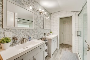 A bathroom with two sinks, a large mirror, patterned wall tiles, and a glass shower enclosure. - Family Home w/ Private Pool: 24 Mi to Disney! (St. Cloud)