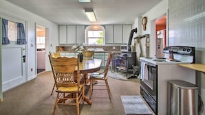 A kitchen with a dining table, chairs, a stove, and a sink. - Rustic Hamilton Farmhouse: Stunning Mtn Views (Hamilton)
