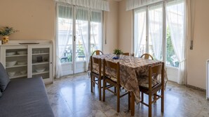 Un comedor con una mesa dispuesta para cuatro, un sofá y un aparador con vajilla.