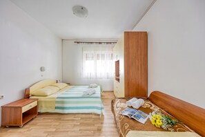 A bedroom with two beds, a wooden wardrobe, a bedside table, and a window with sheer curtains. - Seaside Apt Basic 2 w/ Terrace, Vir, Croatia (Vir)