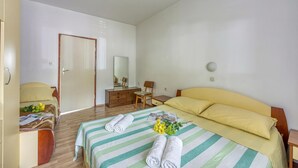 Een hotelkamer met een bed, een bureau, een stoel en een kledingkast.