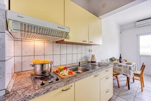 A modern kitchen with a built-in stove, a sink, and a window overlooking the dining area. - Seaside Apt Basic 2 w/ Terrace, Vir, Croatia (Vir)