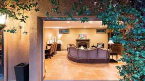 A warmly lit interior with a fireplace, seating area, and framed artwork on the walls.