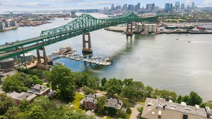 Un pont vert enjambant une rivière, avec un port de plaisance et des immeubles résidentiels au premier plan.