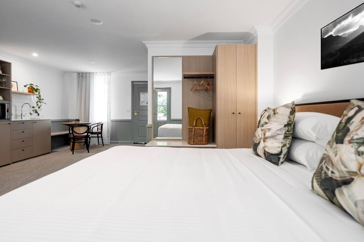Une chambre d’hôtel moderne, dotée d’un grand lit, d’un bureau et d’une armoire.
