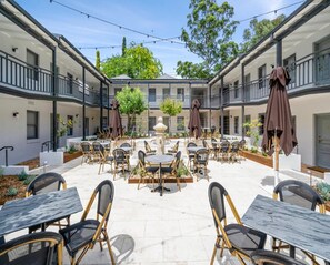A courtyard with outdoor seating, a central fountain, and trees. - Wildes Hotel Kangaroo Valley (Kangaroo Valley)