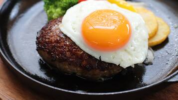 Gros plan d’une assiette de petit-déjeuner avec un œuf au plat, des pommes de terre rissolées et des brocolis.