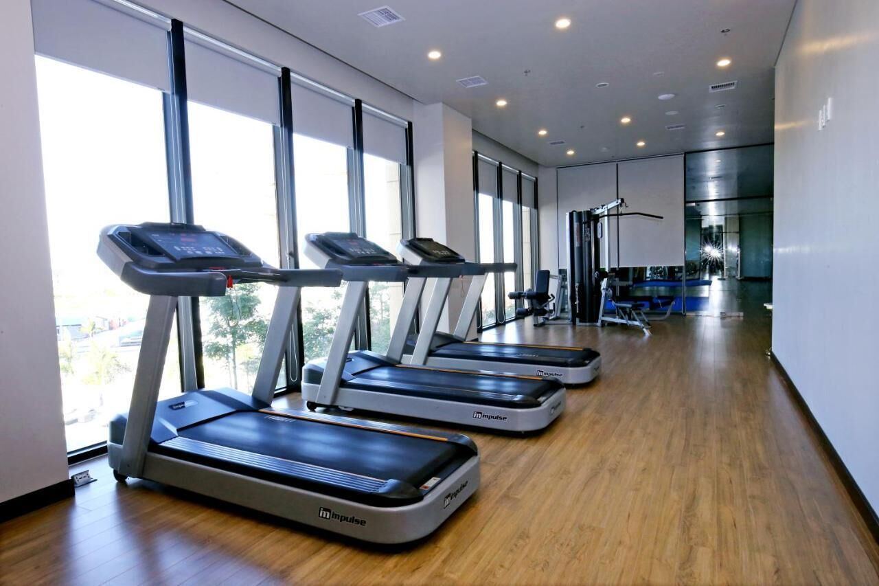 A gym with treadmills, a weight bench, and a mirror.