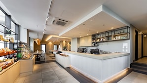 A modern hotel lobby with a central reception desk, seating area, and a staircase leading to upper floors. - Roygent Parks Hai Phong (Hai Phong)