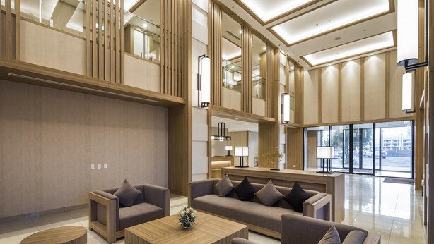 A modern hotel lobby with a high ceiling, large windows, and a mix of seating areas including sofas and a coffee table. - Roygent Parks Hai Phong (Hai Phong)