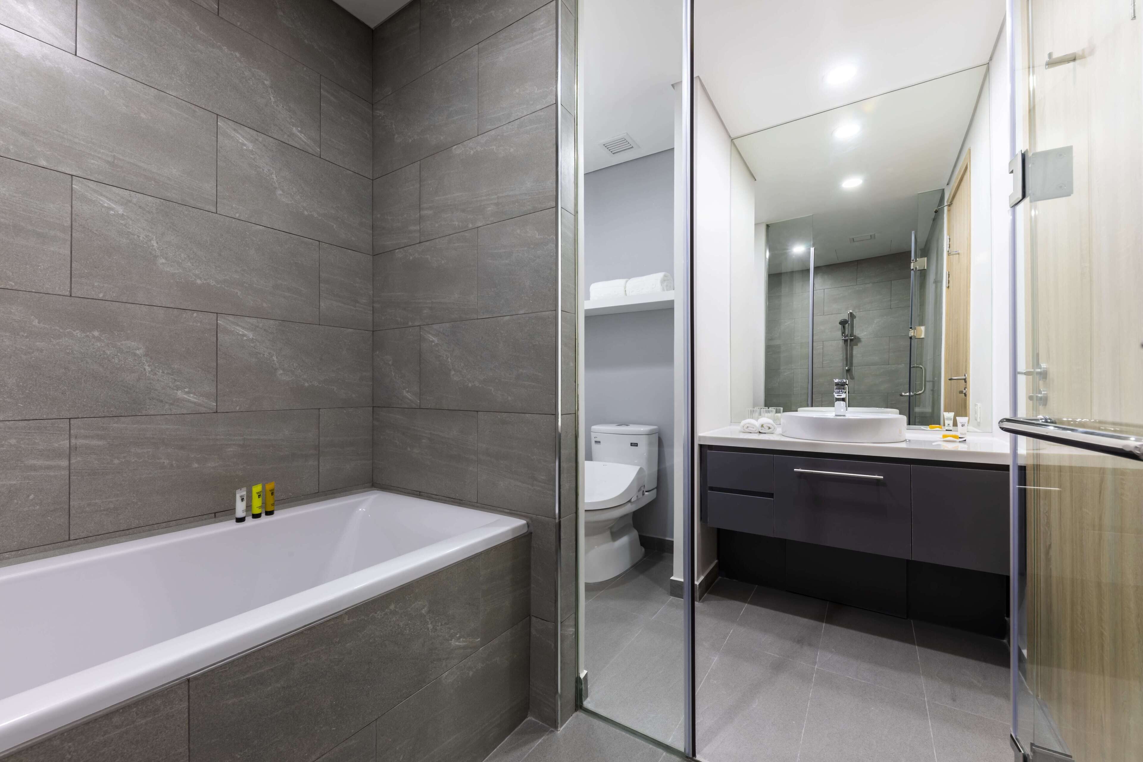 Ein modernes Badezimmer mit Badewanne, Toilette und Waschbecken.