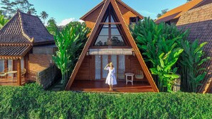 A triangular wooden house with a balcony, surrounded by lush greenery. - Alam Kawi Ubud Resort & Spa (Ubud)