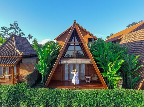 A triangular wooden house with a balcony, surrounded by lush greenery. - Alam Kawi Ubud Resort & Spa (Ubud)