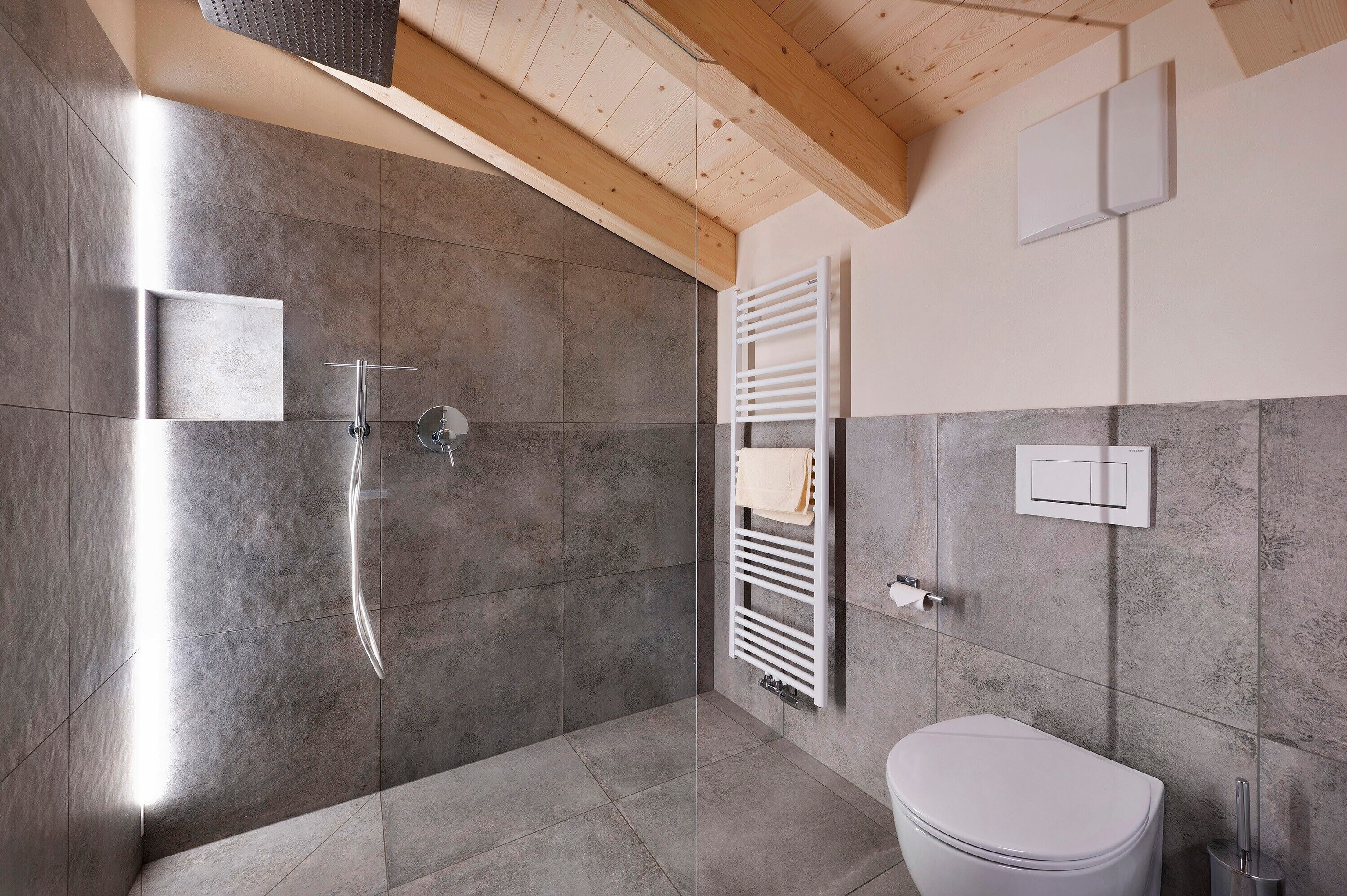 Un bagno moderno con doccia, WC e portasciugamani.